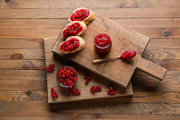 Composition with red currant jam and sandwiches on wooden background