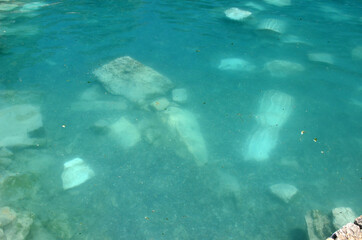 Ruins of ancient column and construction blocks of antique city Hierapolis, in Pamukkale, Turkey under water.