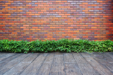 Vintage red brick wall background. brick surface elements. brick wall with green plants and wooden floor. 