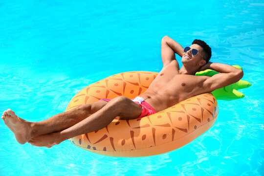 Handsome Man With Inflatable Ring In Swimming Pool