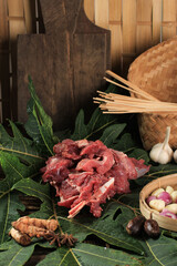 Raw Beef or Lamb above Papaya Leaf, Papain Enzim Make Meat Tender. Cooking Preparation Making, Gule, Gulai, Sate (Satay) or Indonesian Curry for Eid al Adha Menu