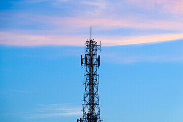 Telecommunication tower silhouette during sunset with pastel sky background. Concept of digital infrastructure, wireless communication, mobile network, and 5G technology