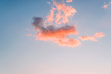 Heavenly sunset landscape. Fiery cloud against the background of the evening blue sky. Minimalistic natural backdrop, high.