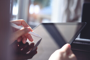 Woman using stylus pen on digital tablet computer, close up
