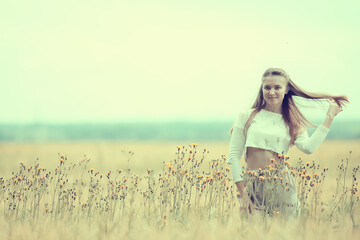 Fototapeta na wymiar blonde with long hair in autumn field / concept of happiness health young adult model in summer landscape