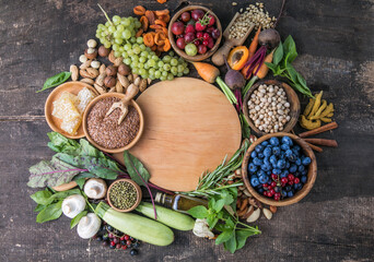 Vegetarian ingredients for cooking. Flat vegetables, fruits, beans, cereals, kitchen utensils, dried flowers, olive oil on a wooden background, top view. Clean, healthy  food