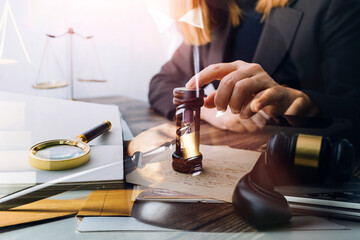 Business and lawyers discussing contract papers with brass scale on desk in office. Law, legal services, advice, justice and law concept picture with film grain effect