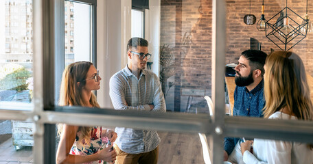 Young people at a business meeting standing in the office