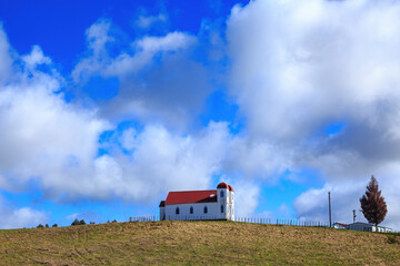 Fototapeta na wymiar The old Ratana Church at Raetihi, New Zealand, standing on a hillside against a beautiful blue sky 