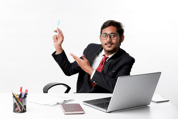 Young indian businessman pointing with hand at office