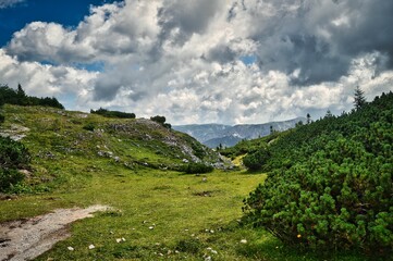 Fototapeta na wymiar Wandern auf der Schneealpe, Steiermark - sommerliche Landschaft mit Berg, Fels, Gipfel, Wanderweg und dramatisch bewölktem Himmel