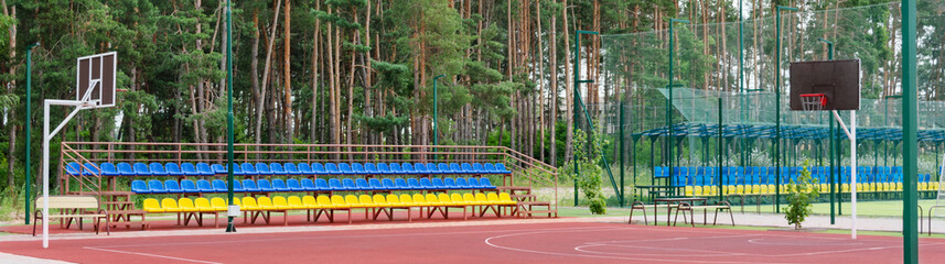 Blue and yellow seats of empty tribunes for audience on sport modern stadium. Concept of fans, cultural environment. Banner