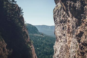 Climber on via ferrata trail crossing a wire bridge