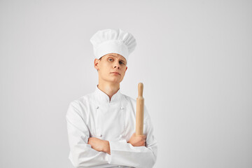 Cheerful chef in the uniform of a rolling pin in the hands of a restaurant
