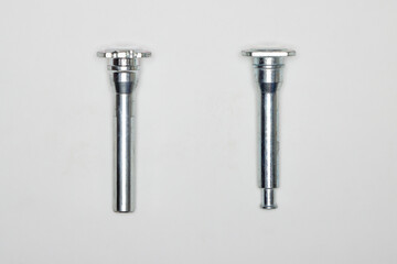 Two metal fingers, machine repair parts. A set of spare parts for servicing the braking system of a vehicle. Details on white background, copy space available.
