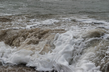 Arabian Ocean waves with foam of blue and turquoise color. Sea foam creating amazing shapes and patterns like glacier. Abstract Arabian Ocean blue water with white wave for background.