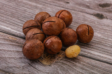 Brown macadamia nut heap over background