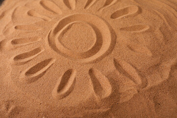 Fototapeta na wymiar Sun Drawn in the Sand on a Beach