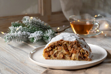 Strudel with apples and green tea on a wooden background. Homemade baking. Christmas cake.
