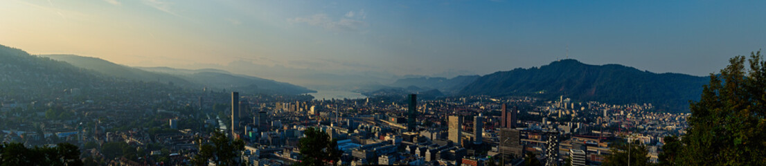 Large panorama of the city of Zurich in the morning with a blue sky from the Waid. With Prime Tower, Uetliberg and Lake Zurich. 