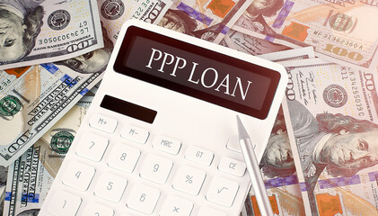 PPP LOAN text on display calculator on dollars background