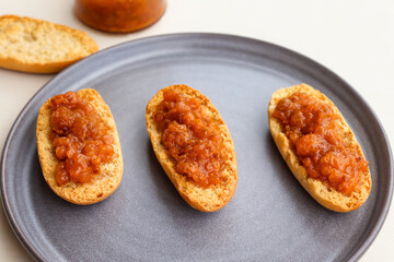 Cardamom rusks with cloudberry jam on gray plate