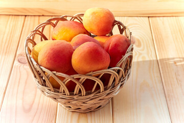 Apricots in a wicker basket on a wooden table