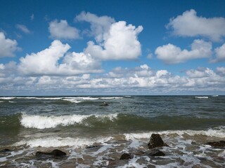 Seascape, natural sea and sky colors, blue sky with white clouds, rocks in the water