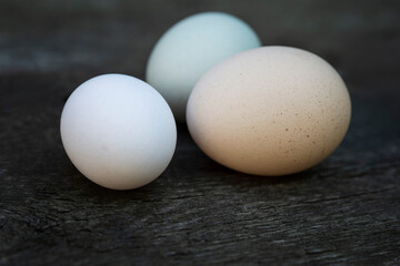 Fresh chicken eggs on an old wooden table. Healthy food and vitamins. Close-up. Space for text.