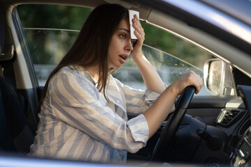 Girl driver being hot during heat wave in car, suffering from hot weather, has problem with a...