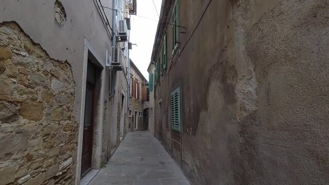 Walking on romantic cobblestone streets in traditional European seaside town. Speed up hyperlapse   point of view walk through narrow old historic streets past old stone houses in Slovenia