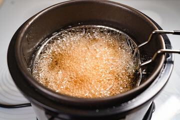 top view. oil boiling in deep fryer. in fryer cook shrimp in batter or potatoes.