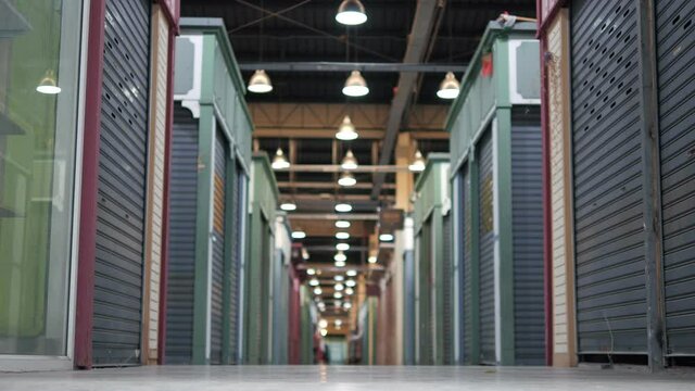 Shop store fronts closed due Coronavirus Pandemic lockdown, metal roller shutter door of store in flea market is closed and locked, economic downturn and epidemics caused stores closing down