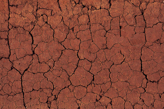 Background of cracked red earth. Texture of dessert, global warming and climate change concept