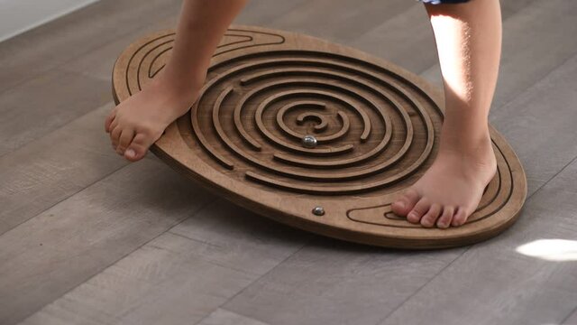 Children's legs on the balance board - brain training and coordination of movements for the child