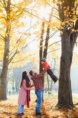 Young family walking in the park. Autumn.