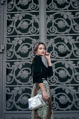 elegant woman on the background of large door shutters. Street style.