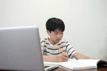 책상에 앉아 열심히 공부하고 있는 소년 a boy sitting at the desk and studying hard