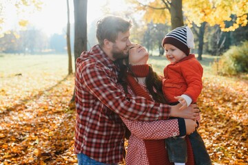 happy family mother father and baby on autumn walk in the park