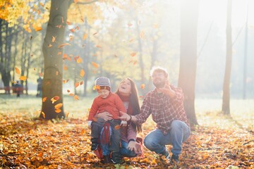 happy young family spending time outdoor in the autumn park