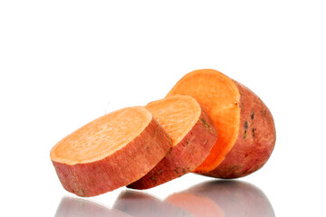 Fototapeta na wymiar One whole fresh juicy sweet potato cut into several slices, close-up, isolated on white.