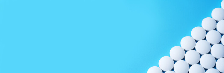 White medical pills on a blue background in the lower right corner.