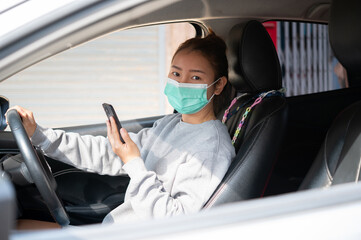 Beautiful young girl in a mask sitting in a car, car insurance