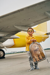 Child with a clear dog backpack standing on the runway