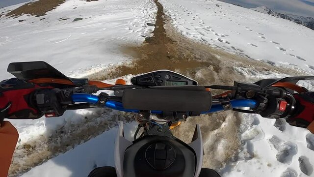 Riding motorcycle on off-road in mountains. Steering wheel view