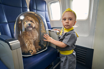 Female child and her poodle aboard the plane