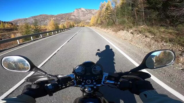 Travel by motorcycle on an asphalt road. Steering wheel view, Altai mountains