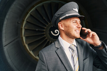 Joyful cute pilot having a phone conversation outdoors © Svitlana