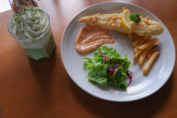 Fish and chips with ice cream matcha frappe on a wooden table. food fotography