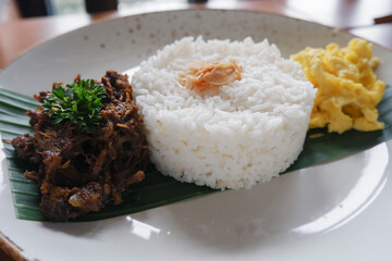 menu for food Madurese black herbs duck. This menu is a typical black jamu duck food from Madura, East Java with the addition of white rice and a few sprinkles of vegetables 